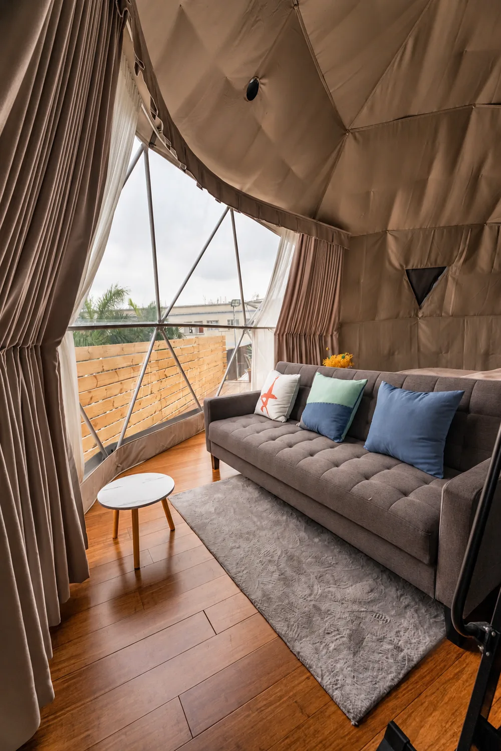 Bank met kussens in een dome, met zicht naar buiten door het panoramaraam
