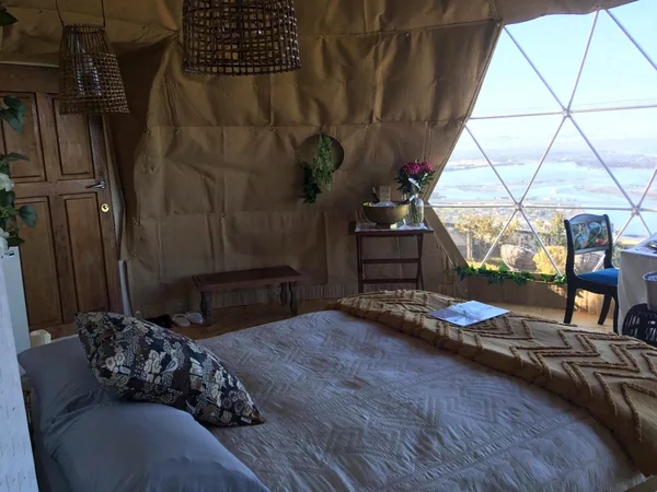 Bed in een dome met uitzicht over de kust