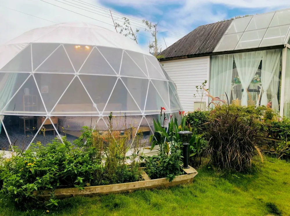 Dome in een achtertuin naast een woonhuis