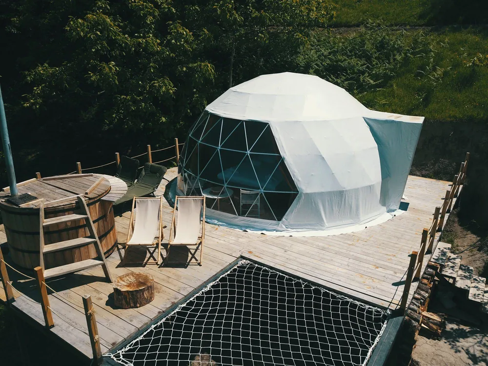 Dome op een houten terras met hottub en ligstoelen