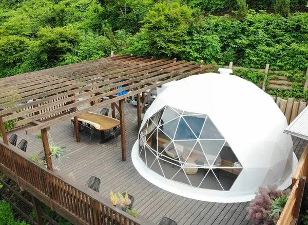 Dome op een terras met pergola en eettafel, van bovenaf gezien