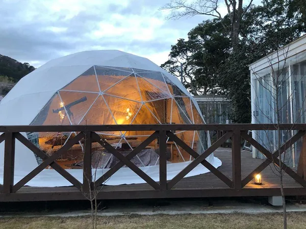 Warm verlichte dome in de schemering achter een houten hekwerk