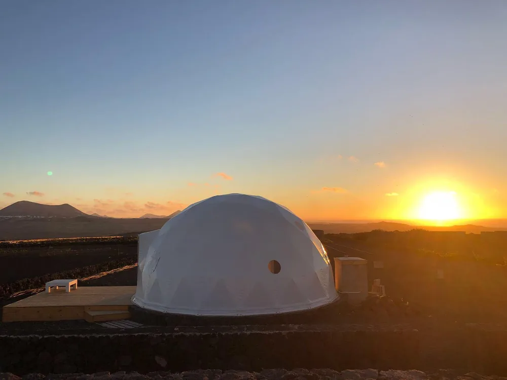 Witte dome bij zonsondergang in een open vulkanisch landschap