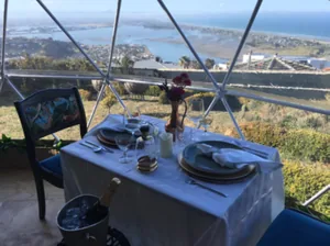 Gedekte tafel voor het panoramaraam met uitzicht over zee