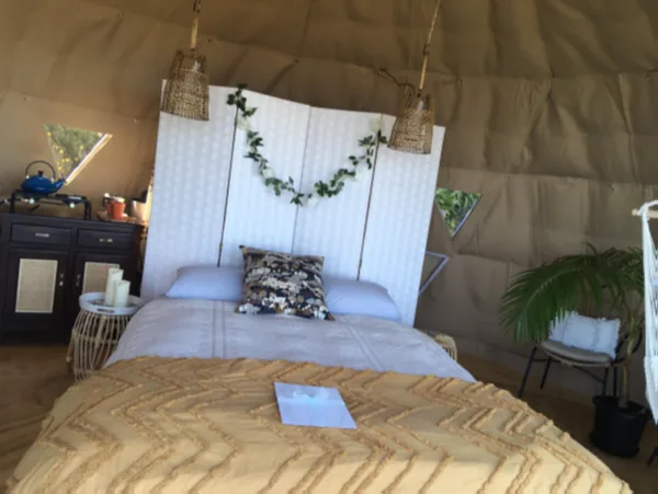Bed in een dome met kamerscherm en warme verlichting