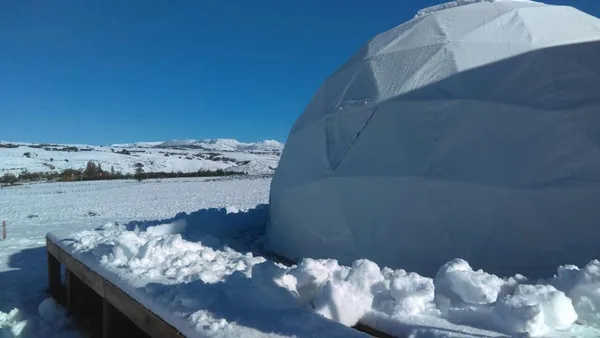 Sneeuw opgewaaid tegen de voet van een dome